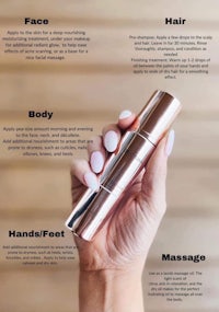 a hand holding a bottle of face, hand, and body care products