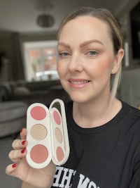 a woman is holding up a blush palette